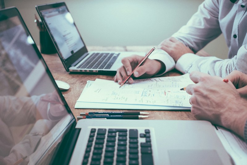 Planning documents and a laptop used to evaluate business strategy